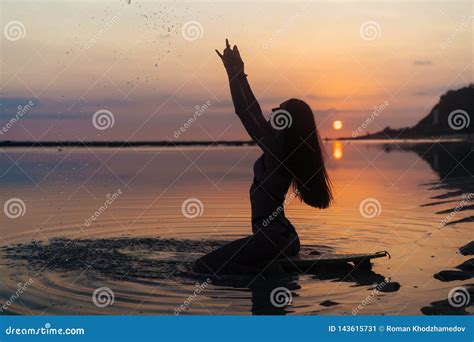 Silhouette Girl In Swimsuit Lying And Posing On Surf Board At Beach