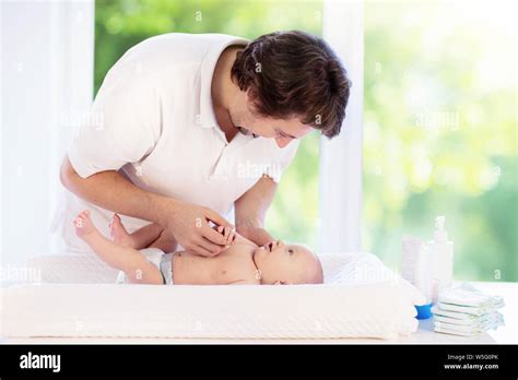 Father Changing Diaper To Baby Boy Dad And Child In Bedroom Parent