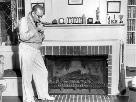 Filmmaker John Ford In Front Of His Mantelpiece Where His Oscar For