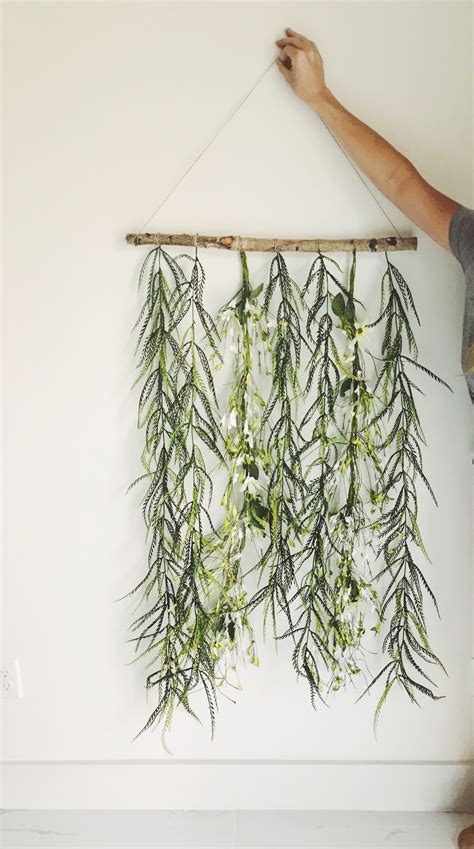 Easy Dyi Decoration Of Greenery And Flowers Hanging Off A Branch On A