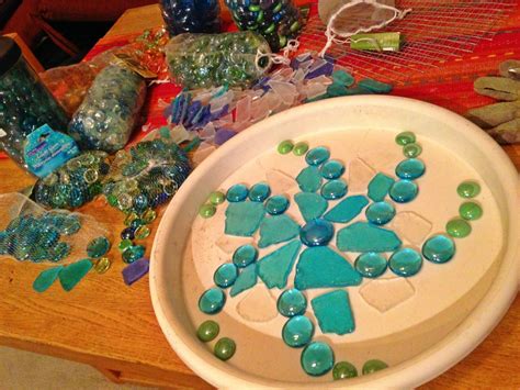 There Is A Plate With Blue And Green Glass Beads On It Next To Other Items