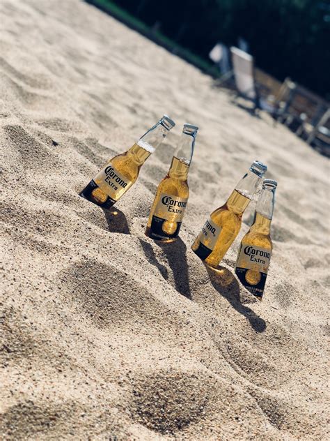 Four Corona Extra Beer Bottles In Sand Photo Free Beer Image On Unsplash