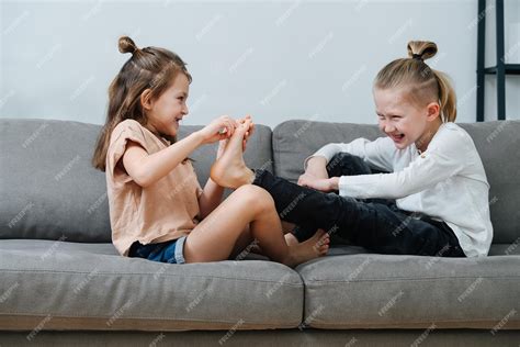 Premium Photo Little Girl Trying To Tickle Boys Foot They Both Laugh