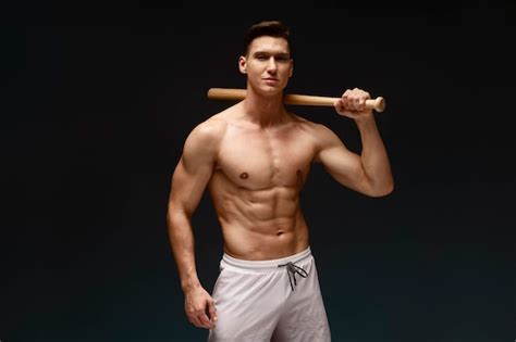 Retrato De Primer Plano De Un Hombre Musculoso Posando Con Un Bate Solo En El Estudio Foto Premium