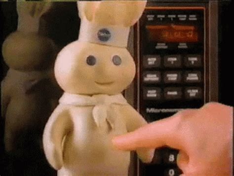 A Close Up Of A Person Pointing At A Toy In Front Of A Microwave Oven