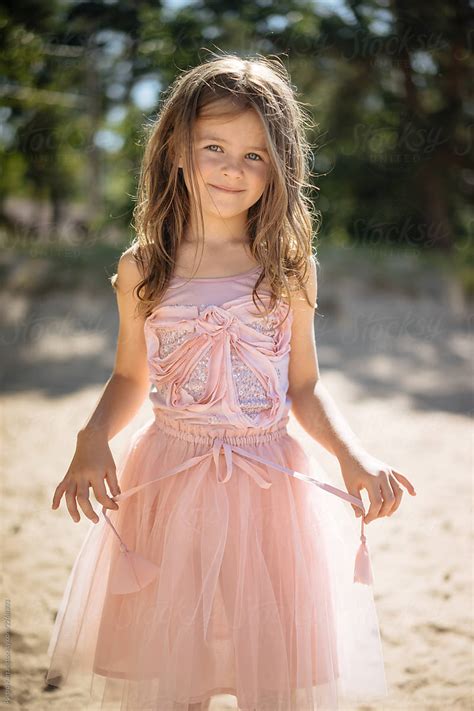 Smiling Girl Touching String On Dress By Stocksy Contributor Pietro Karras Stocksy