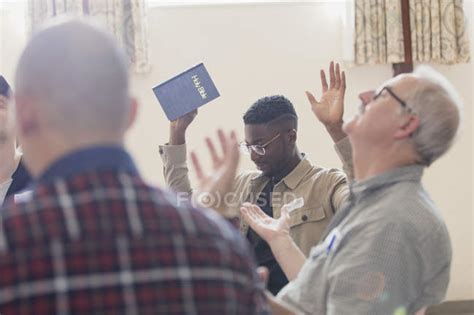 Hombres Con La Biblia Orando Con Los Brazos Levantados En Grupo De