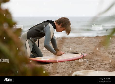 Boy Waxing Surfboard On Beach Stock Photo Alamy