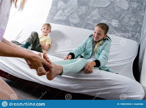 Mutter Kitzelt Die Füße Ihrer Tochter Eine Jugendliche Lacht Stockfoto