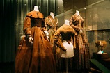Collection of historical costumes in showcase in museum · Free Stock Photo