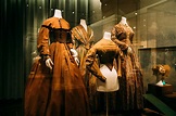 Collection of historical costumes in showcase in museum · Free Stock Photo