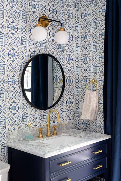 A Bathroom With Blue And White Wallpaper Gold Faucet Marble Counter Top