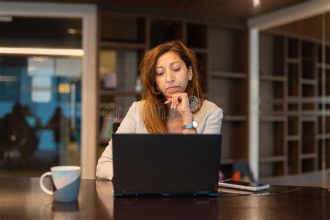 Portrait Of Businesswoman Using Laptop Computer At Night In Office