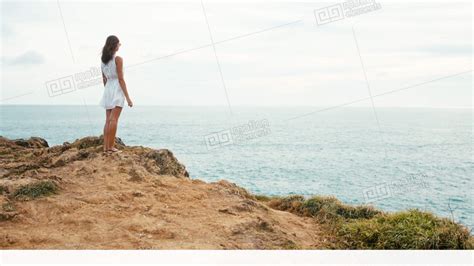 Woman Walks Along The Edge Of The Cliff And Looks At The Endless Ocean At Sunset Stock Video