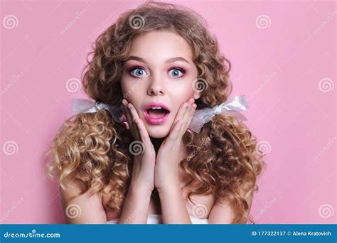 Woman With Pink Lips And Nails Surprise Holds Cheeks By Hand On Pink Background Stock Image