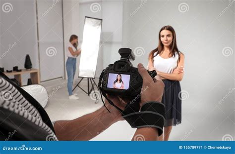 Professional Photographer Picture On Camera And Model With Assistant In