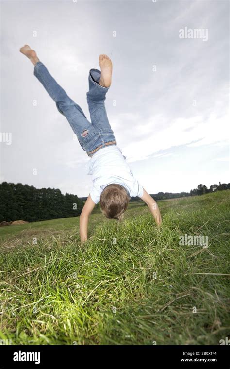 Boy Doing Handstand On A Meadow Stock Photo Alamy