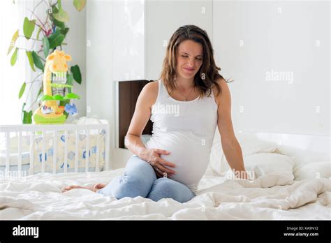 Young Beautiful Pregnant Woman In Pain With Labor Contraction Sitting