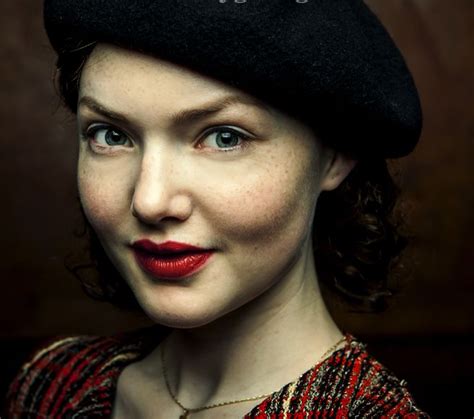 A Woman Wearing A Black Beret And Red Lipstick