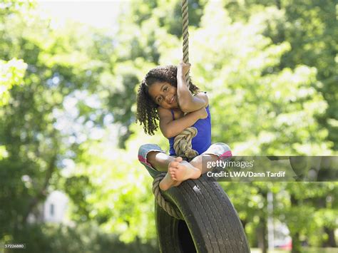 Portrait Of Girl On Tire Swing High Res Stock Photo Getty Images