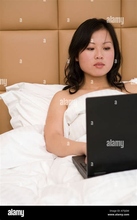 Nude Woman Typing On Laptop In Bed Stock Photo Alamy