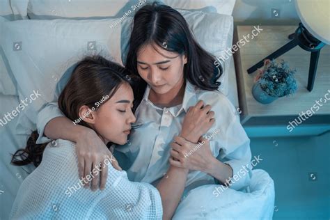 asian beautiful lesbian couple lying down on bed and hugging each other attractive romantic