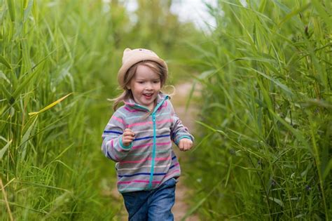 premium photo little cute girl running in the green grass