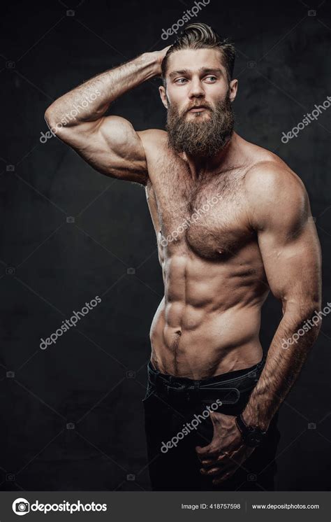 Tipo barbudo con el torso desnudo posando en un fondo oscuro fotografía de stock fxquadro