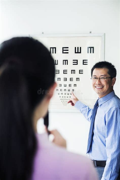 Optometrist Administering An Eye Exam On A Eye Chart Stock Image