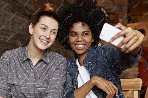 Free Photo Two Cheerful Lesbians Of Different Races Having Fun Indoors