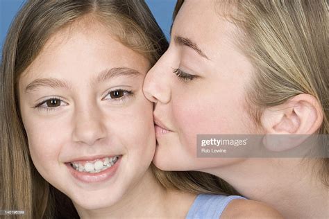 Portrait Teenage Girl Kissing Younger Sister Photo Getty Images