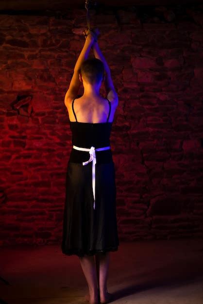 Premium Photo Bdsm Concept Woman In Black Dress Stands With Her Back