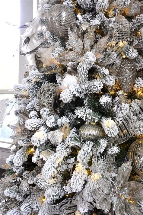 A Christmas Tree With Silver And White Decorations