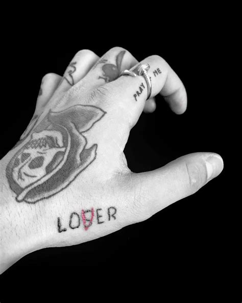 A Persons Hand With Tattoos On It And The Word Lover Written In Red Ink
