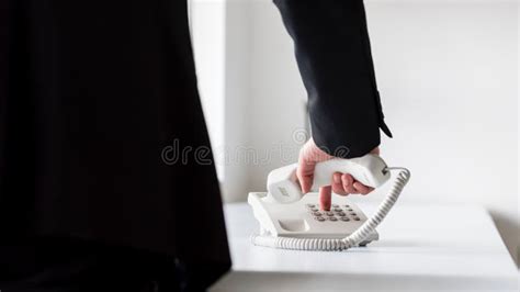 Businessman Dialing Telephone Number On A Classical White Landline