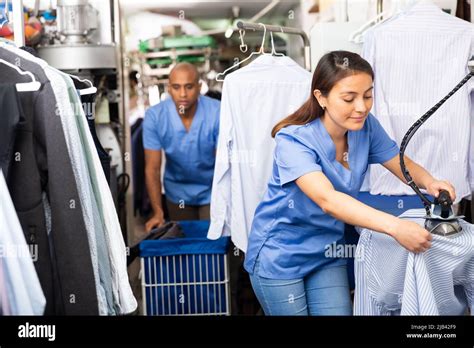 Woman laundry worker ironing shirt at dry-cleaning Stock Photo - Alamy