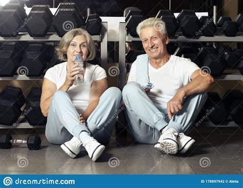 Portrait Of Senior Couple Drinking In Gym Stock Photo