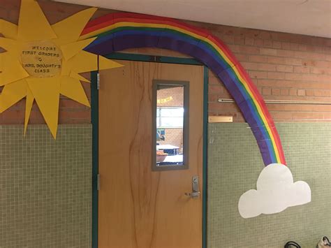 A Rainbow Painted On The Side Of A Building With A Sun And Clouds Above It