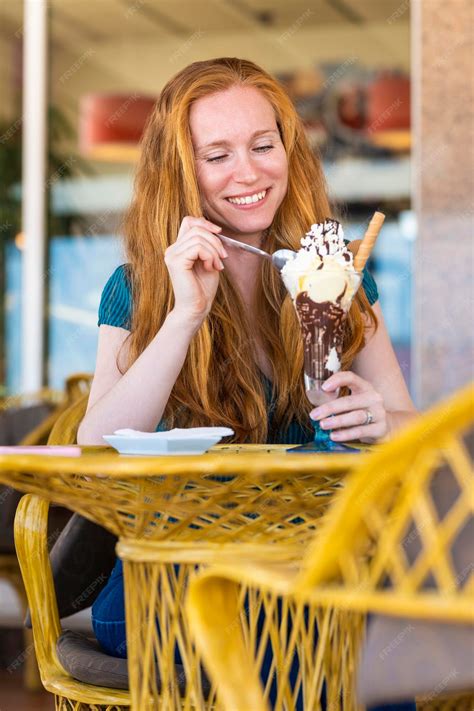 Premium Photo Redhead Woman Having A Glass Of Ice Cream On A Terrace Of An Ice Cream Parlor
