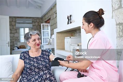 Home Care Nurse Taking Senior Womans Blood Pressure Stock Photo