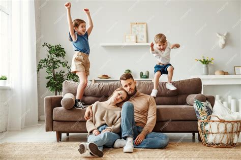 Premium Photo Exhausted Young Parents Sitting On Floor And Hugging
