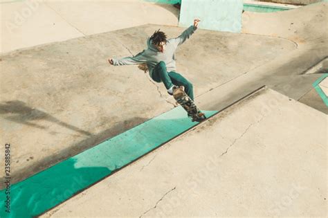 Guy Practicing Skateboarding And Doing Tricks In A Skatepark Stock