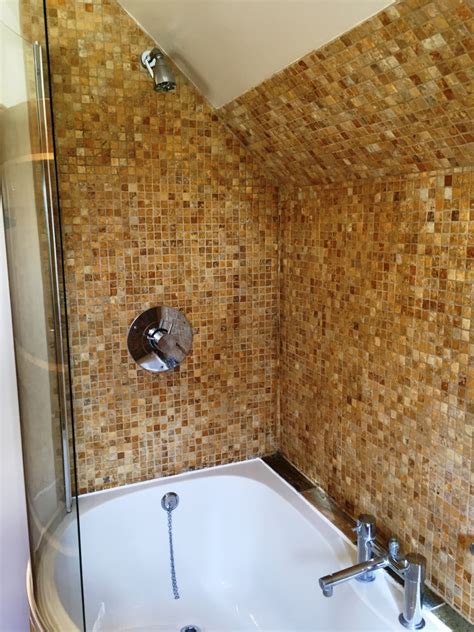 Beachy bathroom features a tub nook with upper walls clad in silver and blue metallic wallpaper and lower walls clad in cream tumbled marble tiles filled with a cream marble tiled tub. Refreshing Marble Shower Tiles | Cleaning Tile