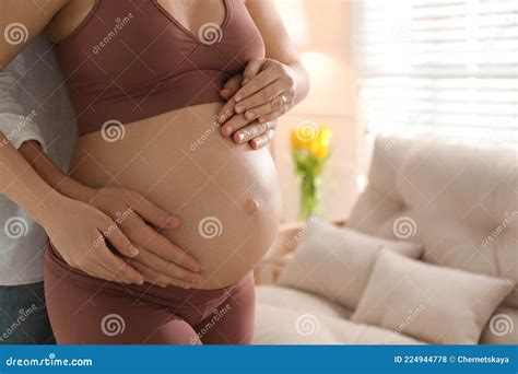 Man Touching His Pregnant Wife S Belly At Home Closeup Space For Text
