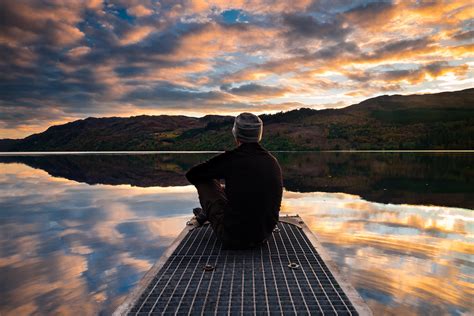 Man Sitting By Lake Royalty Free Stock Photo