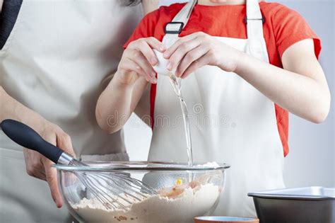 A Mother Is Teaching Her Little Daughter How To Cook Stock Photo
