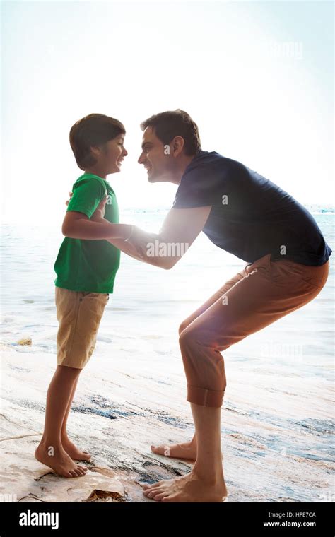 Cheerful Father Lifting Son At Beach On Sunny Day Stock Photo Alamy