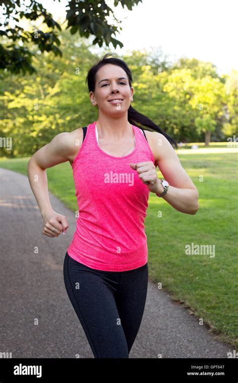 Young Woman Running Through The Park Stock Photo Alamy