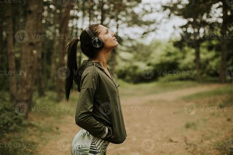 Young Beautiful Female Runner Listening To Music And Taking A Break