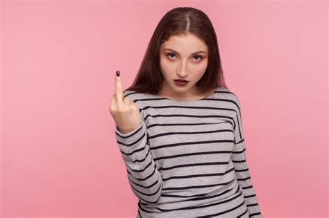 premium photo portrait of angry vulgar woman in striped sweatshirt showing middle finger rude